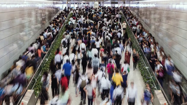 这是香港中环地铁站内使用自动扶梯的商业人士和通勤者的时光流逝视频素材