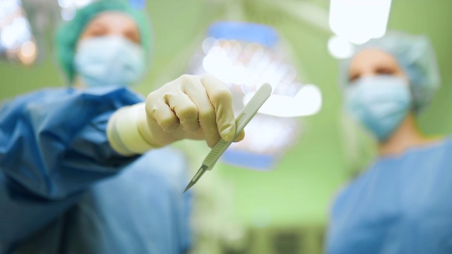 注意锋利的手术刀:两名女医生在手术中视频下载
