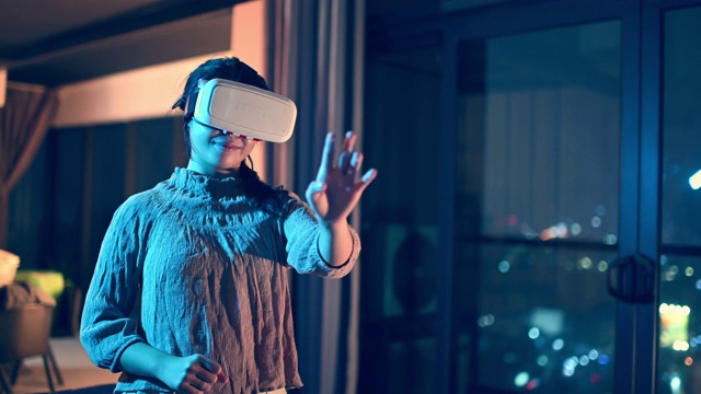 一位亚洲华裔少女戴上VR眼镜，在客厅体验3D虚拟游戏体验视频下载