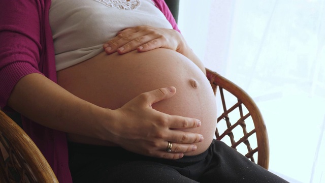 一个女人用手摸着怀孕的肚子视频素材