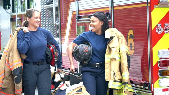 两个女消防员走在消防车旁边视频下载
