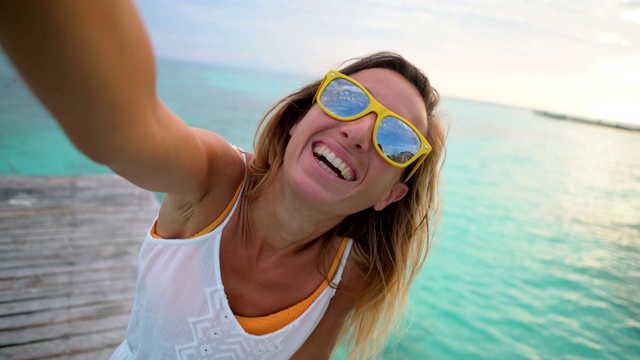 快乐的年轻女人在热带天堂的海滩上拍自拍视频在蓝色的礁石海滩女孩旅行视频聊天度假在墨西哥坎昆视频素材