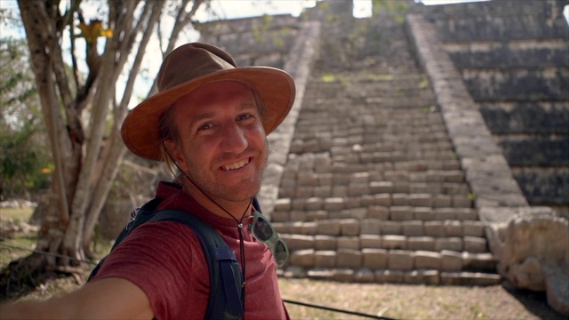 一名男子在墨西哥古玛雅金字塔附近自拍的慢动作视频，人们旅行个人视角的概念。男人分享视频聊天朋友快乐的周游世界视频下载