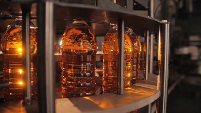 几瓶向日葵油在管道里流动。粮食生产。视频下载