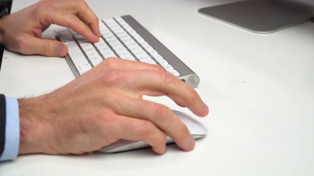 男人的手用鼠标在电脑键盘上打字视频素材