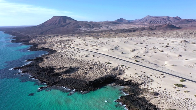 西班牙，加那利群岛，富埃特文图拉，穿过Corralejo沙丘自然公园的道路鸟瞰图视频下载