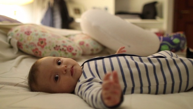 可爱的小男婴躺在床上伸手去摸腿视频素材