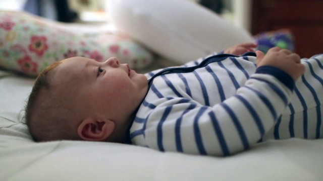 漂亮帅气的婴儿躺在床上看着镜头显得很可爱视频素材