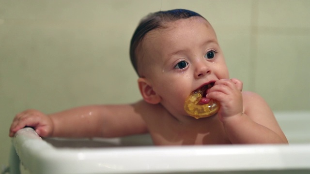 可爱的宝宝在浴缸里。清洁、清洗和沐浴幼童。宝宝把玩具放进嘴里出牙视频下载