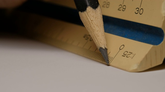 特写使用三角形比例尺与铅笔在白纸上画出建筑图纸、模型。1:25。视频下载