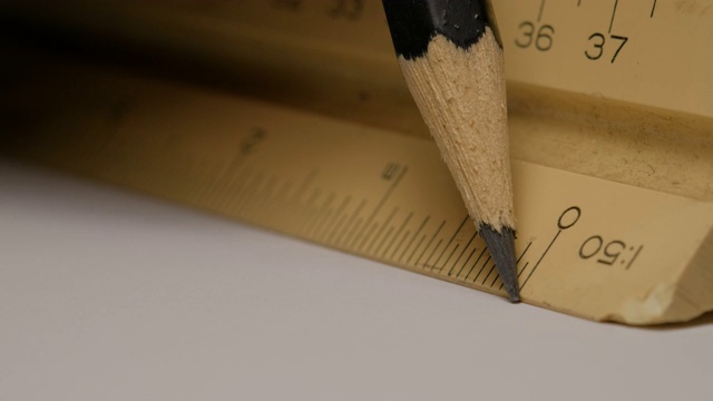 特写使用三角形比例尺与铅笔在白纸上画出建筑图纸、模型。规模1:50。视频下载