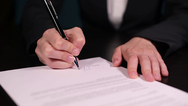 女人签了一份合同，特写的手和笔在纸上视频素材