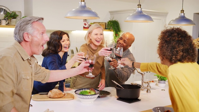 一群成熟的朋友在家里聚会，一起上菜，一起喝酒——用慢镜头拍摄视频下载