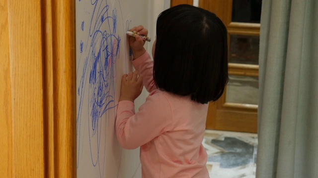 孩子在家里的墙上画画视频素材