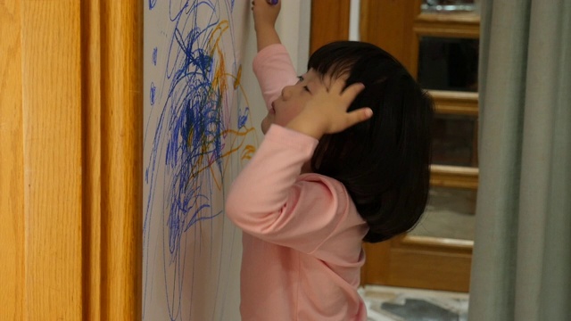 孩子在家里的墙上画画视频素材