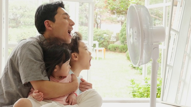一家人在客厅享受电扇吹出的凉风视频下载