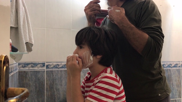 爸爸在浴室里刮胡子，儿子在模仿他的4K视频视频素材
