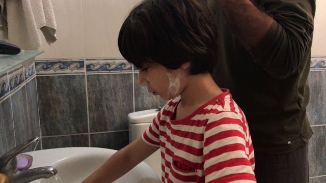 爸爸在浴室里刮胡子，儿子在模仿他的4K视频视频素材