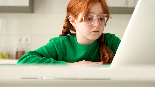 网络欺凌的受害者。阴沉的红发小女孩，戴着眼镜，看着笔记本电脑视频素材