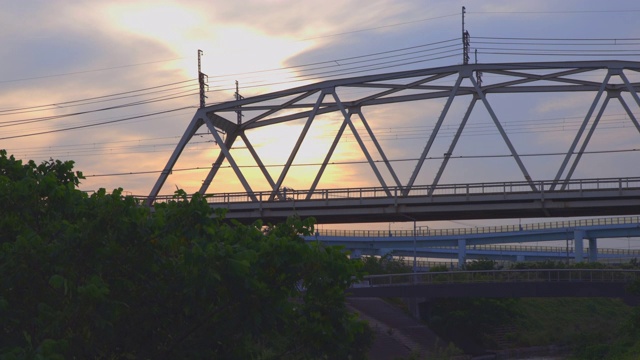 一列沐浴在夕阳中的火车穿过横滨郊区的一座铁路桥视频素材