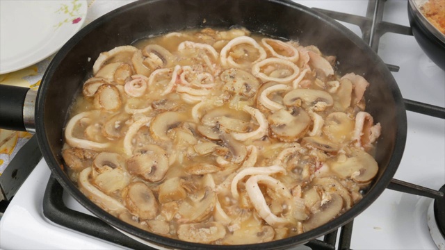 用平底锅煮鱿鱼和蘑菇的酱汁，特写视频素材