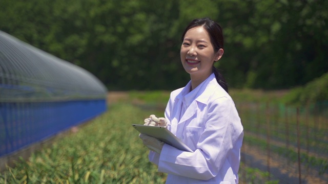 智能农业-研究人员看着相机，微笑着与一个数字平板电脑在农业领域视频下载
