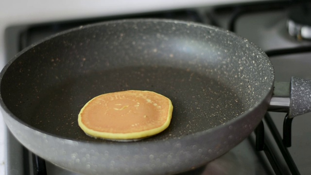 用木铲在煎锅上煎薄饼。漂亮的金色酥皮和膨松的面糊视频素材