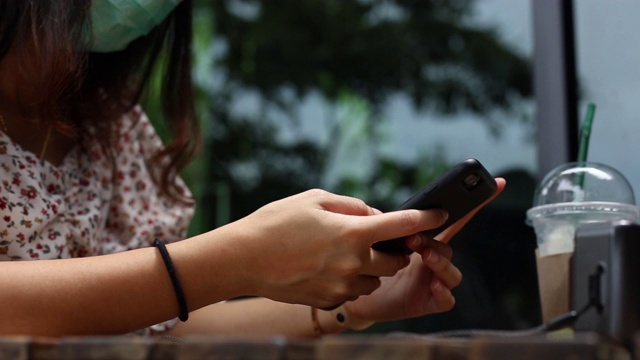 年轻女性度假时在咖啡馆使用智能手机视频素材