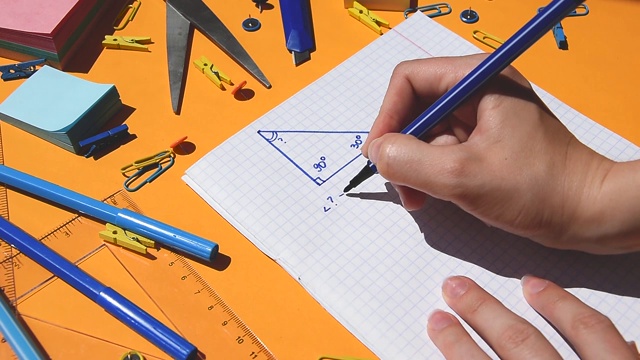 学生在纸上画三角形和解三角形几何，写数学作业，回到学校，学习用品视频素材
