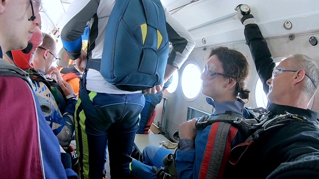 跳伞前，教练和一名女子坐在飞机上。视频素材