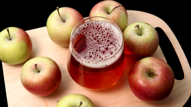把苹果汁倒进一个透明的玻璃杯里。健康饮食理念视频素材