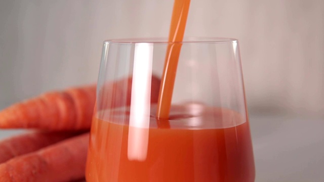 将胡萝卜汁倒入玻璃杯中，特写，选择性聚焦视频素材