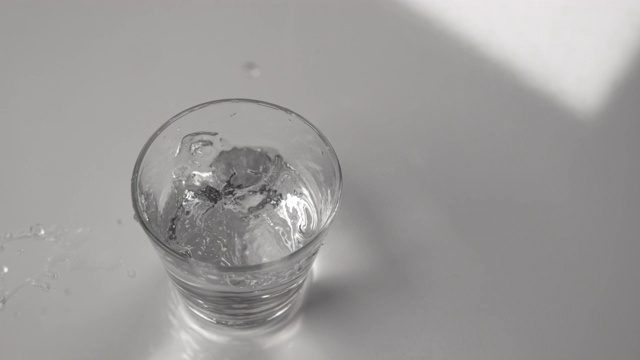 近距离观察:透明玻璃杯中的水在地震时溢出。视频素材