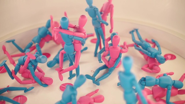 蓝色和粉色的玩偶摆出不同的姿势。视频下载