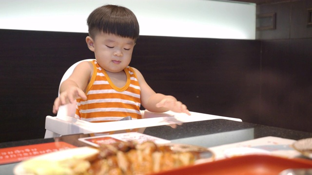 亚洲宝宝在餐厅的晚餐时间饿了。视频素材