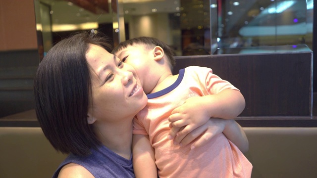 快乐的亚洲母亲享受与她的儿子在餐厅午餐。视频素材
