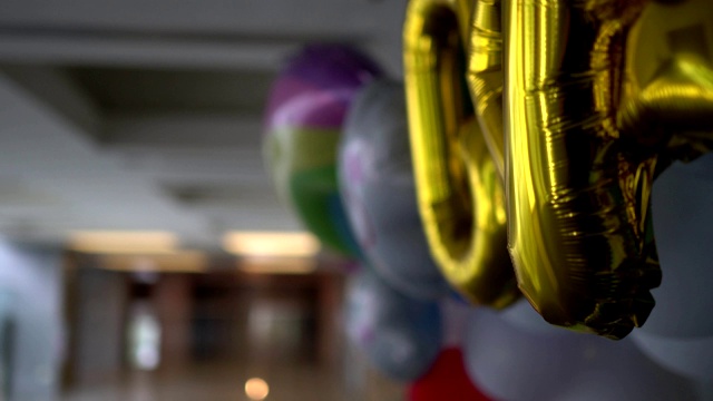 近距离观察庆典大厅里的彩色气球。关注金色气球。视频素材