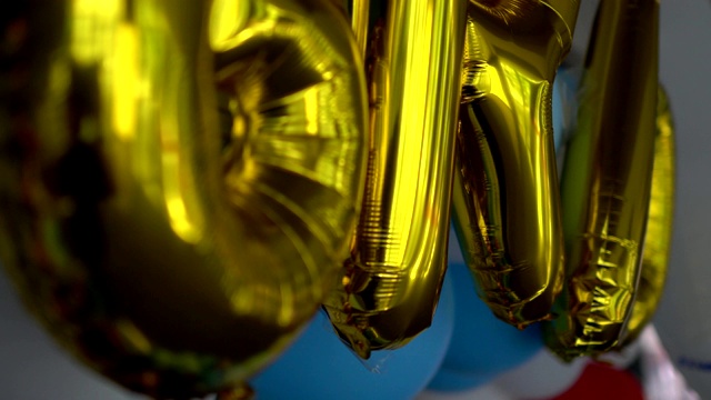 近距离观察庆典大厅里的彩色气球。关注金色气球。视频下载
