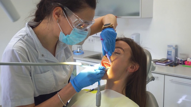 牙医在诊所里治疗女孩的牙齿视频下载