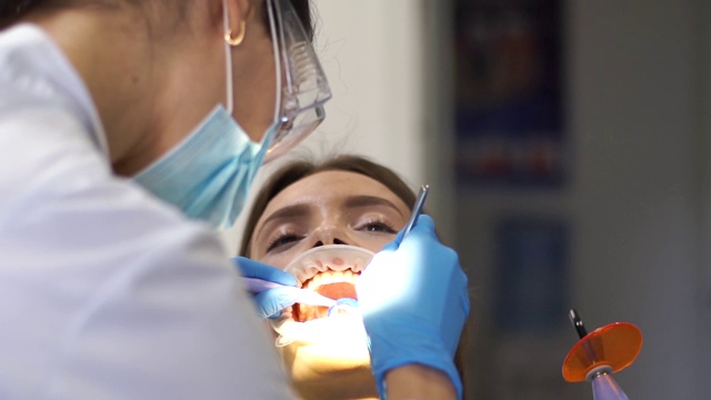 牙医在诊所里给一个女孩治疗牙齿视频下载