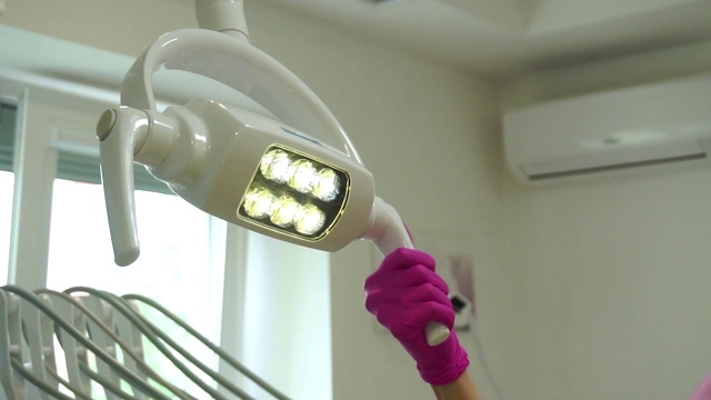 牙医戴着手套为病人调整灯视频下载