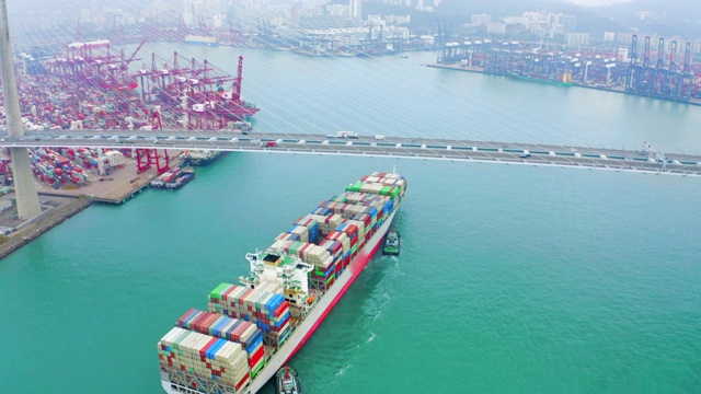 鸟瞰图集装箱货船前往码头商业港口或集装箱仓库与香港城市景观的商业物流，进出口，航运或运输。视频下载