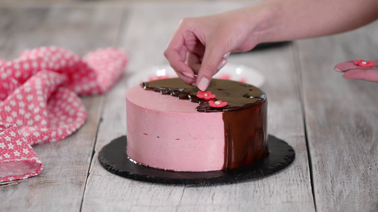 女性用糖花装饰自制的草莓慕斯蛋糕视频下载