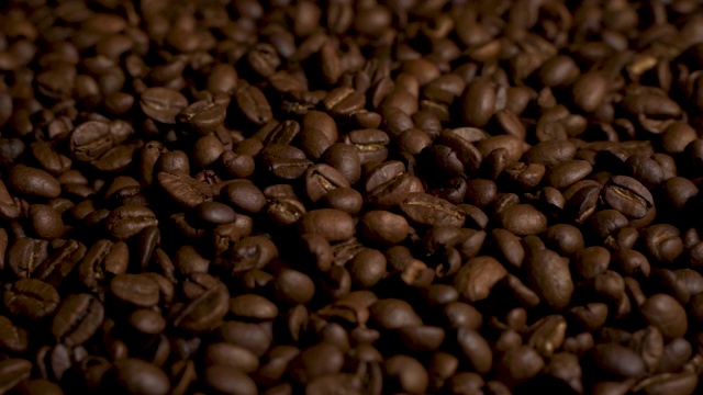 棕色的、深烤的咖啡豆缓缓落下视频下载