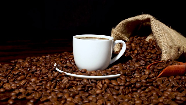 粗麻袋咖啡豆和白色杯子满新鲜咖啡视频下载