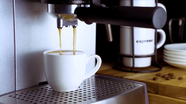 浓缩咖啡机把咖啡倒在白色咖啡杯里视频下载