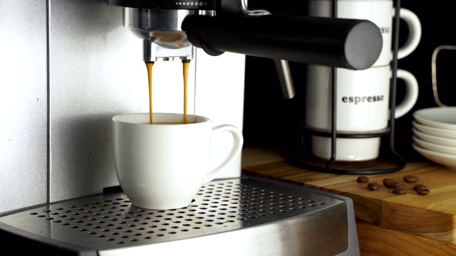 咖啡机将浓缩咖啡倒入白色的咖啡杯中视频下载