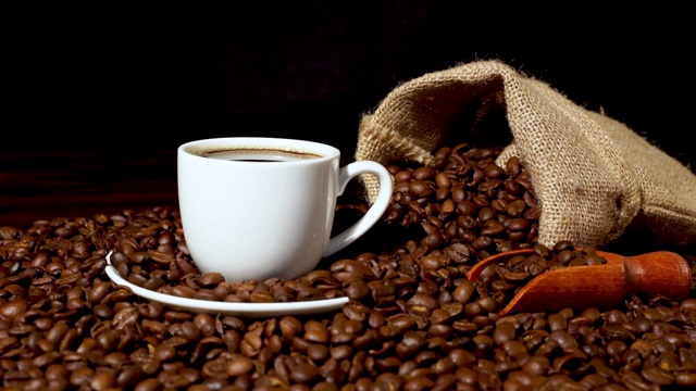 用白咖啡杯、粗麻袋和烘好的咖啡豆装上新鲜咖啡视频下载
