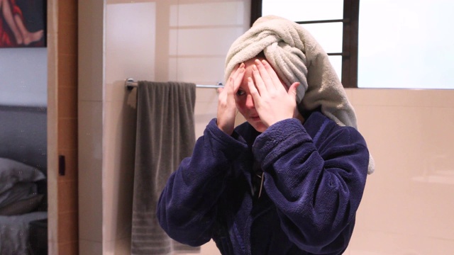 一个16岁的女孩洗完澡后正在洗脸。视频素材