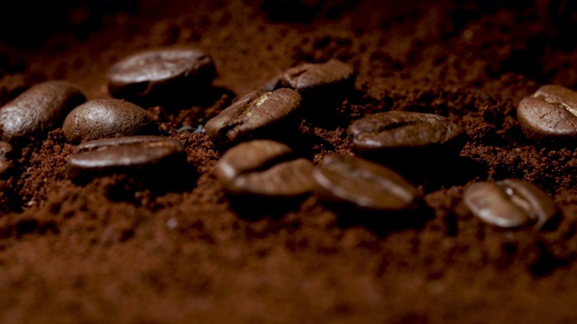 咖啡豆堆在一堆烟雾缭绕的咖啡粉上视频下载